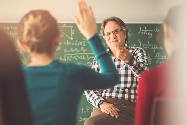 aluna de mão levantada para tirar dúvida com o professor