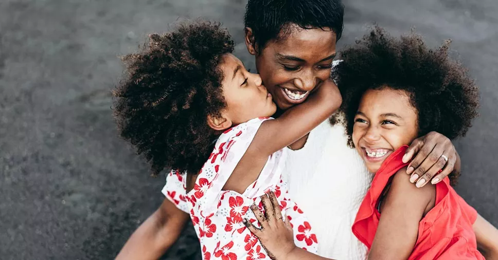 mulher com duas crianças representando as mães que trabalham com carteira assinada
