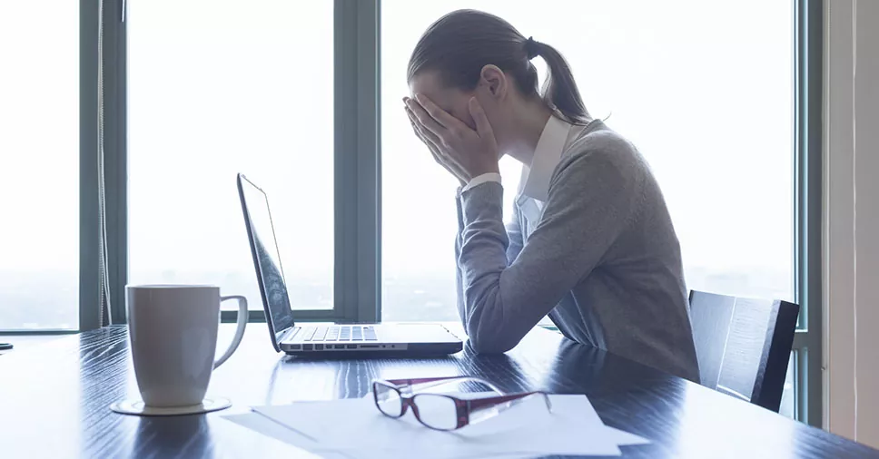 mulher no escritório com as mãos no rosto desacreditada após a morte do familiar será beneficiada com a licença